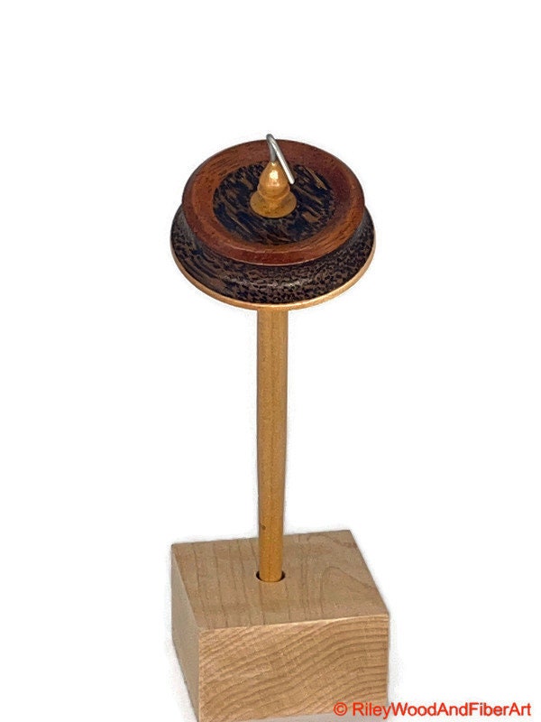 Top Whorl Drop Spindle - African Mahogany, Black Palm, Maple - 29g on white background