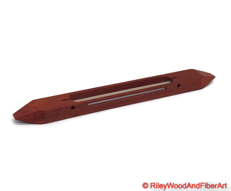 12 inch Padauk open bottom boat shuttle with a white background