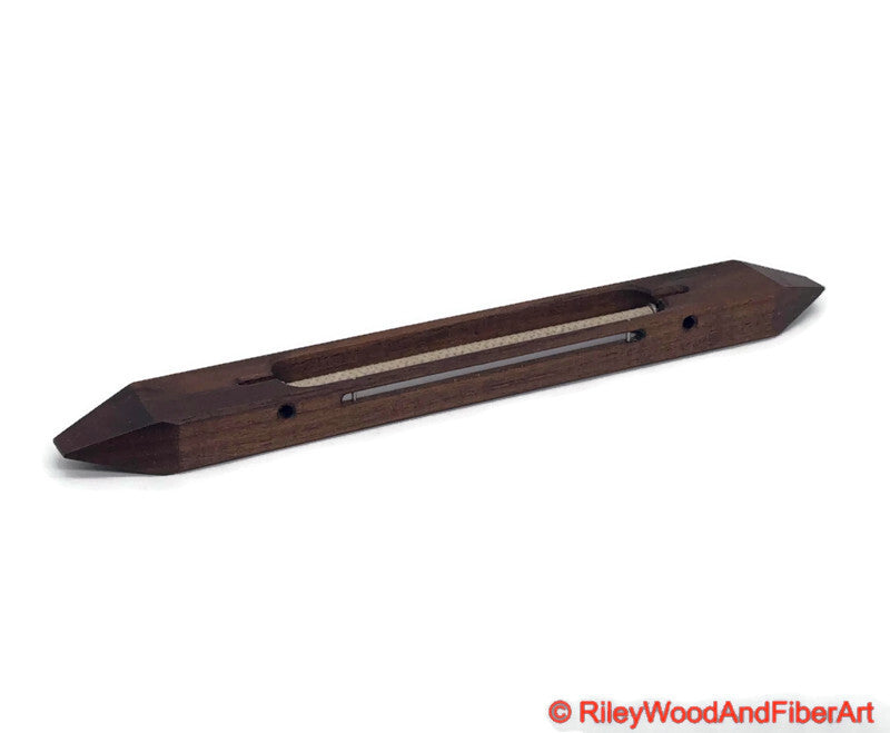 12 inch Walnut open bottom boat shuttle with a white background