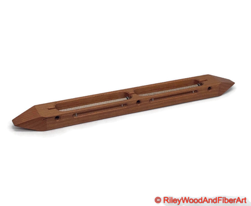 Cherry closed bottom double bobbin boat shuttle on a white background