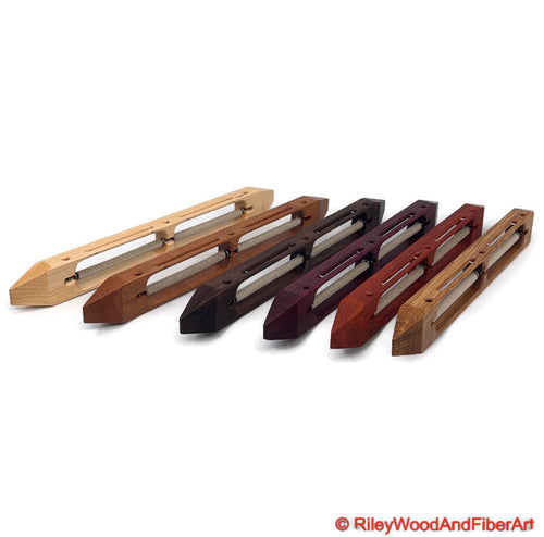 An array of open bottom double bobbin boat shuttles standing on edge on a white background