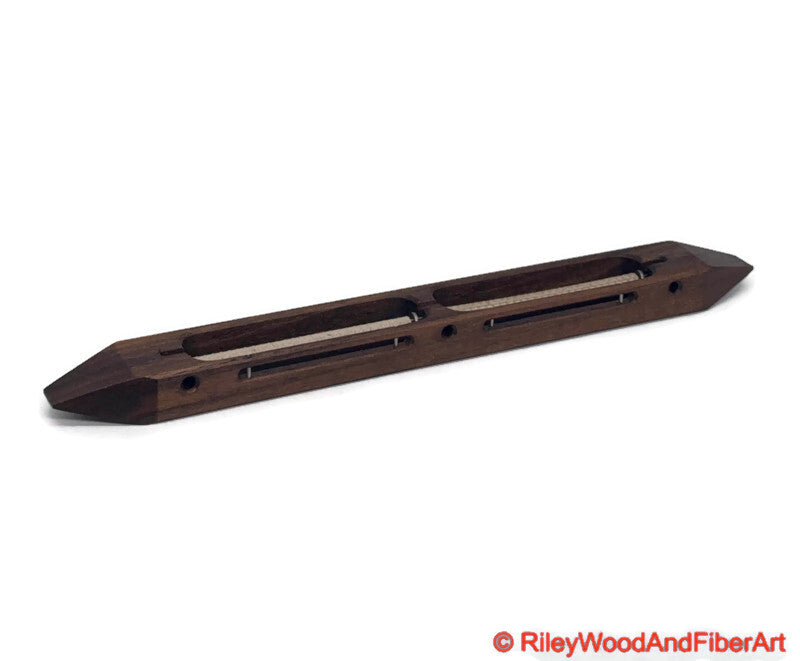 Walnut closed bottom double bobbin boat shuttle on a white background