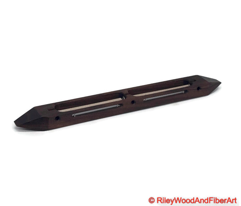 Walnut open bottom double bobbin boat shuttle on a white background